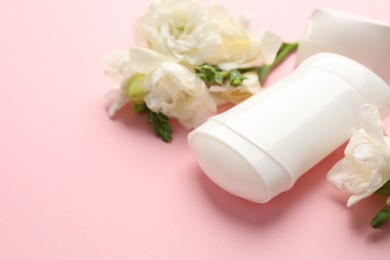 Photo of Solid deodorant and beautiful eustoma flowers on pink background, closeup