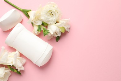 Photo of Solid deodorant and beautiful eustoma flowers on pink background, flat lay. Space for text