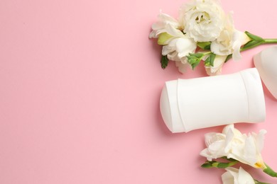 Photo of Solid deodorant and beautiful eustoma flowers on pink background, flat lay. Space for text