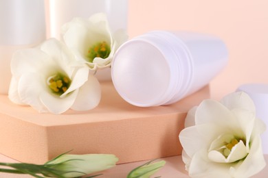 Photo of Roll-on deodorant and beautiful eustoma flowers on beige background