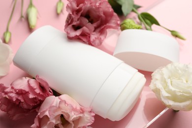 Photo of Solid deodorant and beautiful eustoma flowers on pink background, closeup