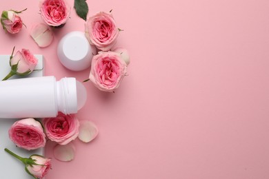 Photo of Roll-on deodorant and beautiful rose flowers on pink background, flat lay. Space for text