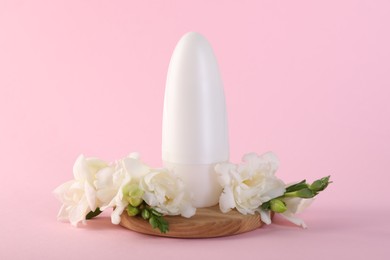 Photo of Roll-on deodorant and beautiful eustoma flowers on pink background