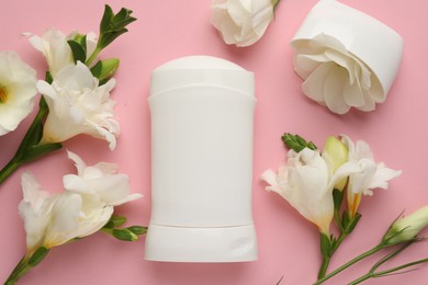 Photo of Solid deodorant and beautiful eustoma flowers on pink background, flat lay