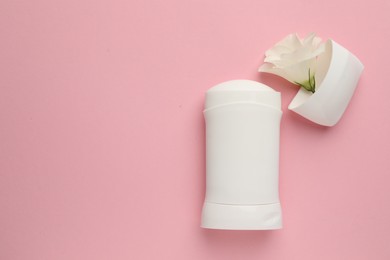 Photo of Solid deodorant and beautiful eustoma flower on pink background, top view. Space for text