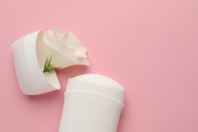 Photo of Solid deodorant and beautiful eustoma flower on pink background, top view. Space for text