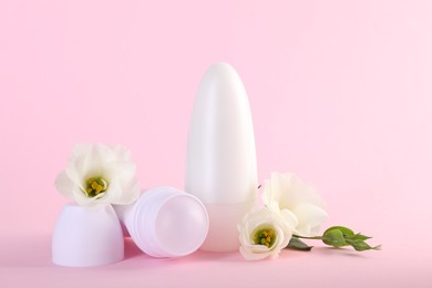 Photo of Roll-on deodorants and beautiful eustoma flowers on pink background