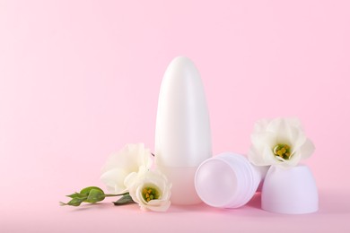 Photo of Roll-on deodorants and beautiful eustoma flowers on pink background