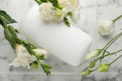 Photo of Solid deodorant and beautiful eustoma flowers on white marble table, top view