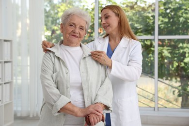 Healthcare worker supporting senior patient in hospital