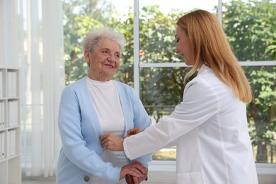 Healthcare worker supporting senior patient in hospital