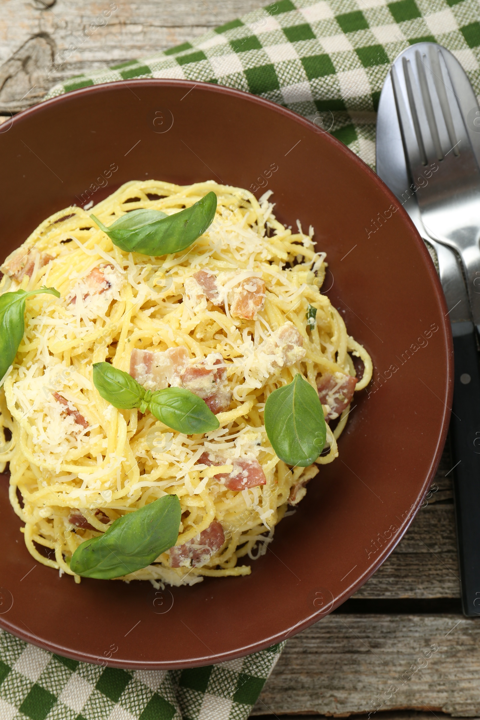 Photo of Delicious pasta Carbonara served on wooden table, flat lay