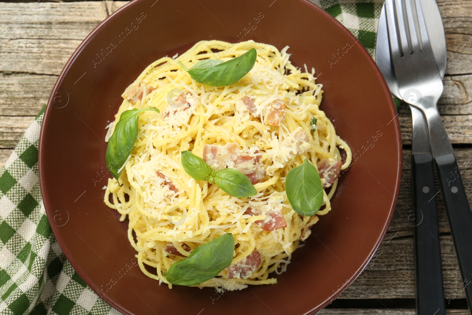 Photo of Delicious pasta Carbonara served on wooden table, flat lay