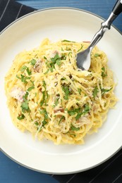 Photo of Delicious pasta Carbonara served on blue wooden table, top view