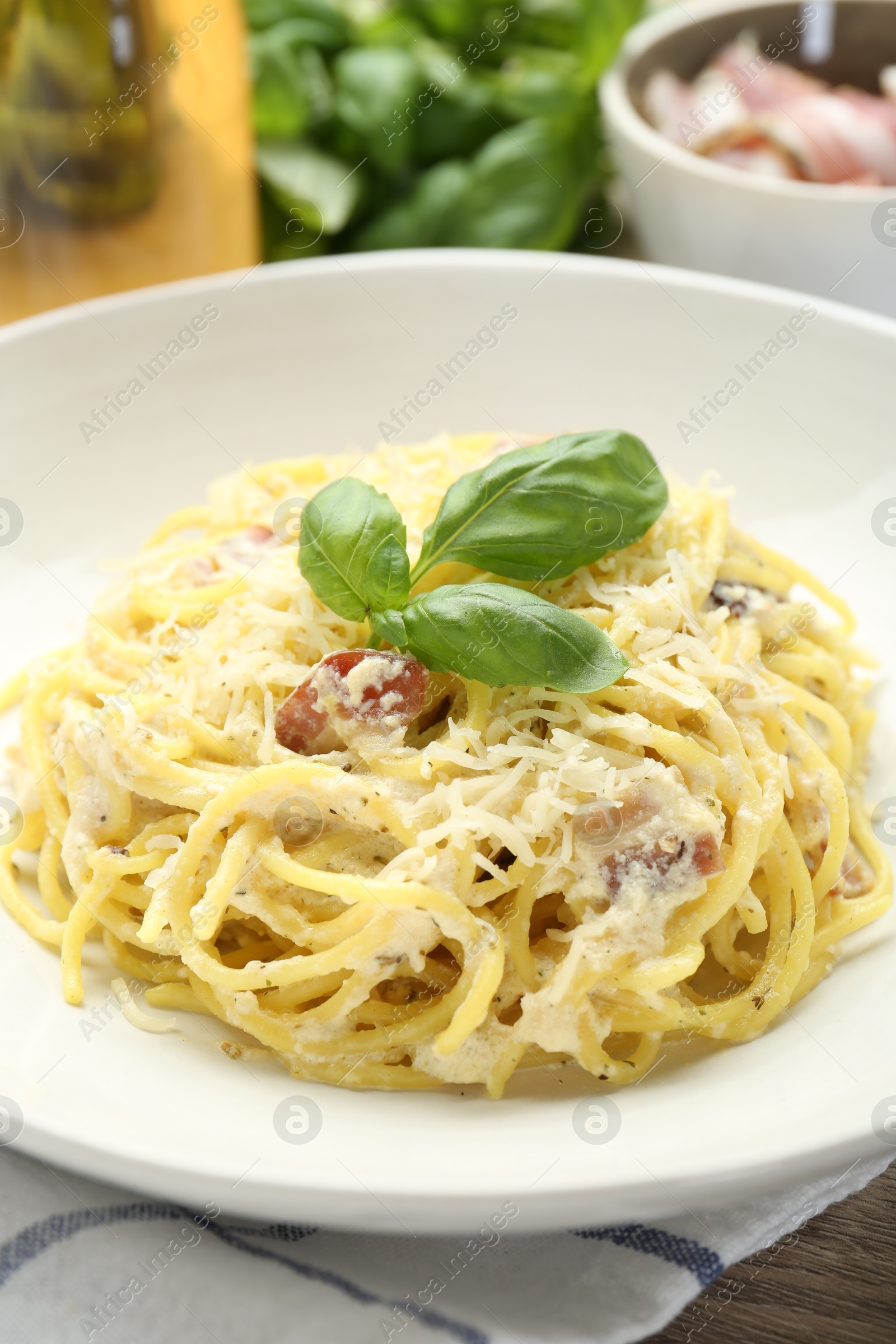 Photo of Delicious pasta Carbonara in bowl on table, closeup