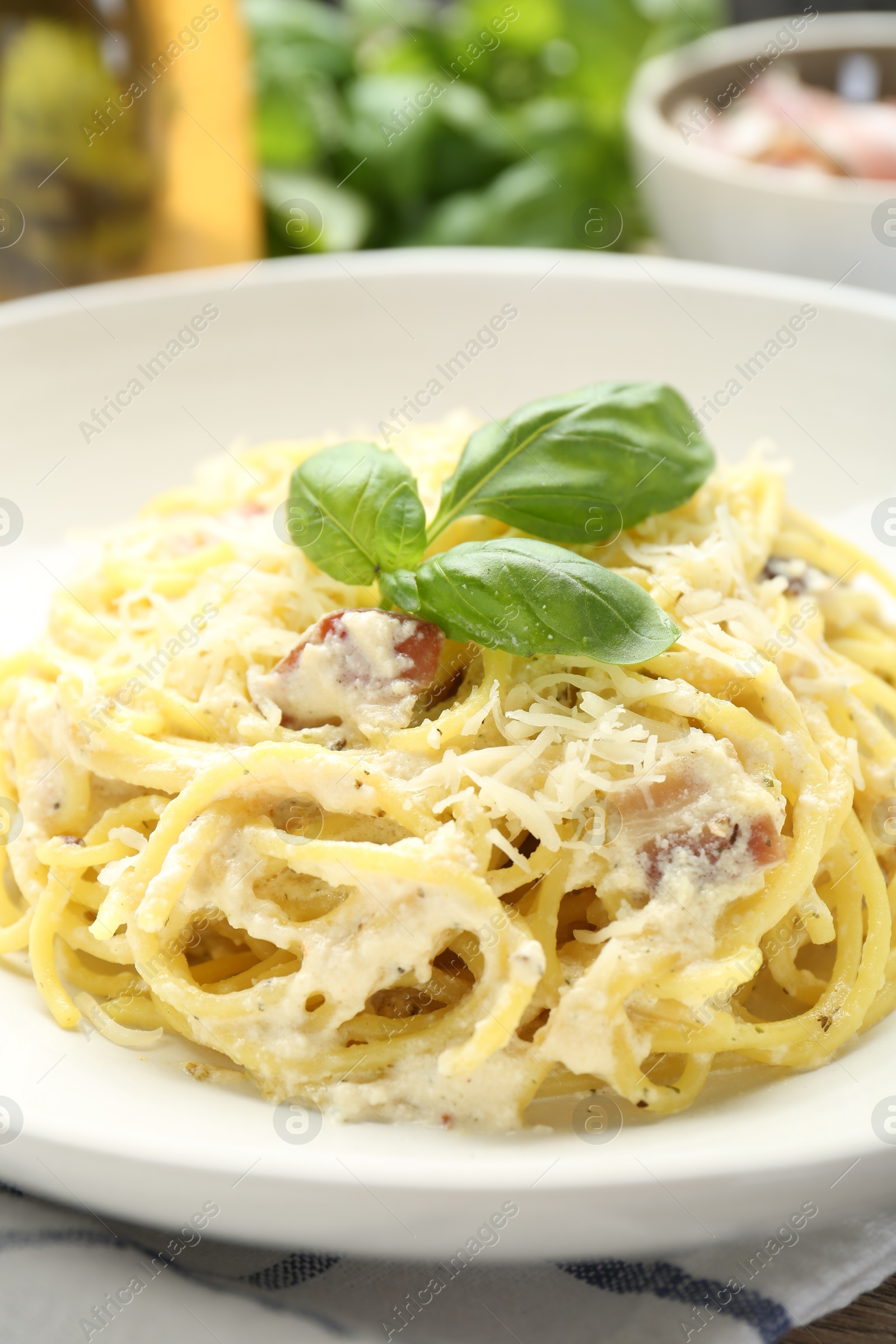 Photo of Delicious pasta Carbonara in bowl on table, closeup