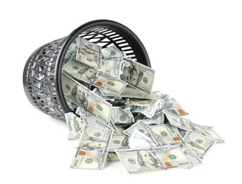 Photo of Many dollar banknotes and overturned trash bin isolated on white