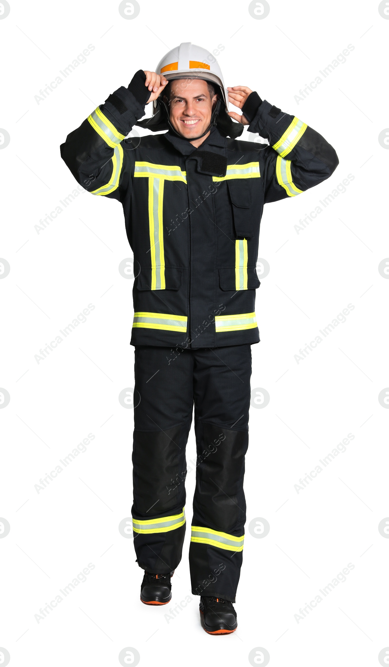 Photo of Full length portrait of firefighter in uniform wearing helmet on white background