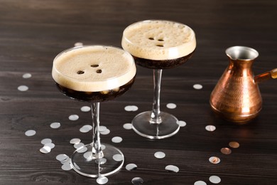 Photo of Fresh coffee cocktails in glasses, confetti and cezve on wooden table