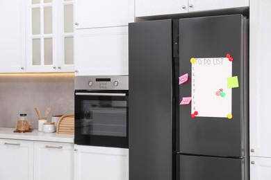 Photo of Magnetic board with to do list and notes on refrigerator in kitchen