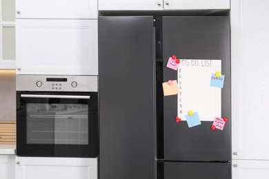 Photo of Magnetic board with to do list and notes on refrigerator in kitchen