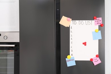 Photo of Magnetic board with to do list and notes on refrigerator in kitchen