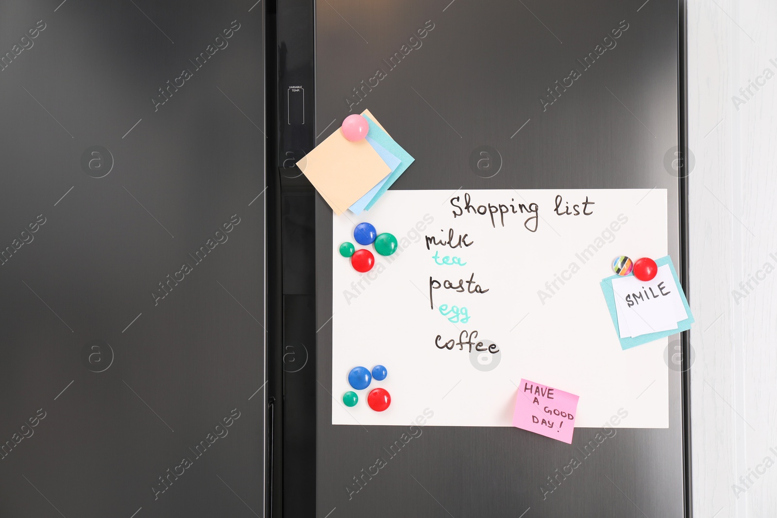 Photo of Magnetic board with shopping list and notes on refrigerator