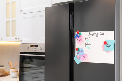 Photo of Magnetic board with shopping list and notes on refrigerator in kitchen