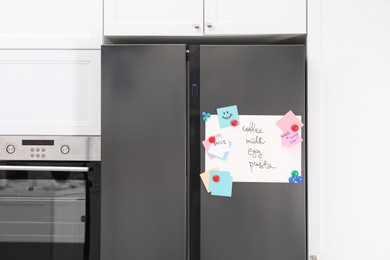 Magnetic board with shopping list and notes on refrigerator in kitchen