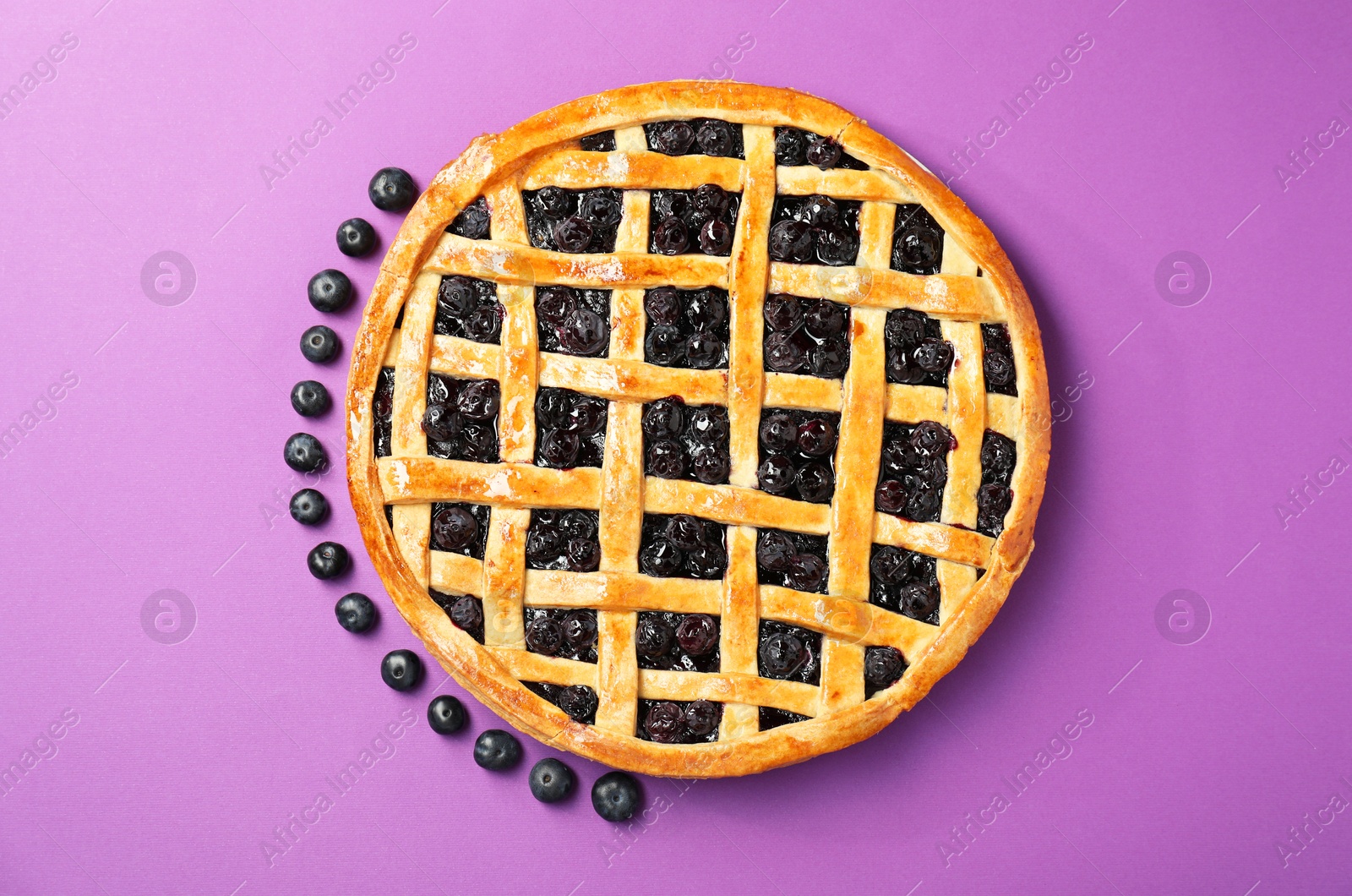 Photo of Tasty homemade pie with blueberries on purple table, top view