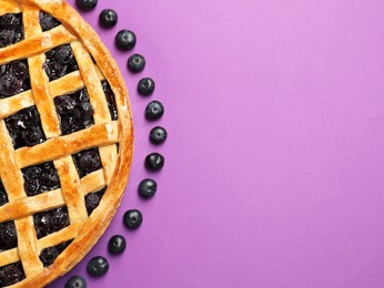 Photo of Tasty homemade pie with blueberries on purple table, top view. Space for text