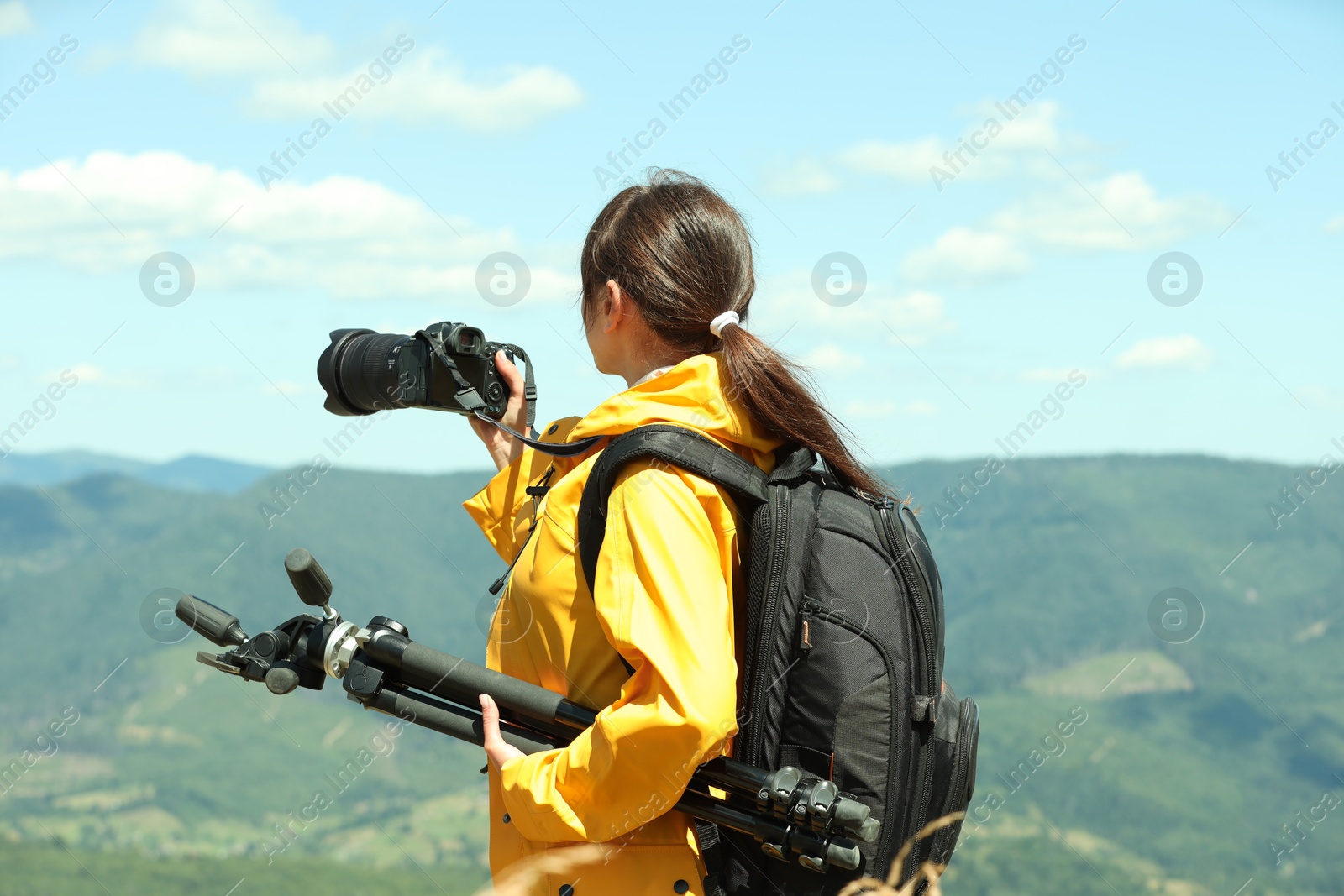 Photo of Photographer with backpack and professional equipment taking picture of beautiful mountains