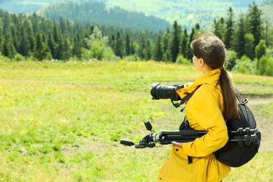 Photo of Photographer with backpack, camera and other professional equipment in mountains. Space for text