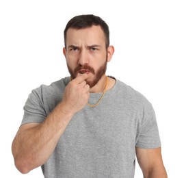 Young man blowing whistle on white background