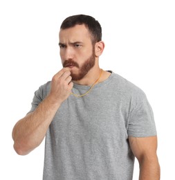 Young man blowing whistle on white background