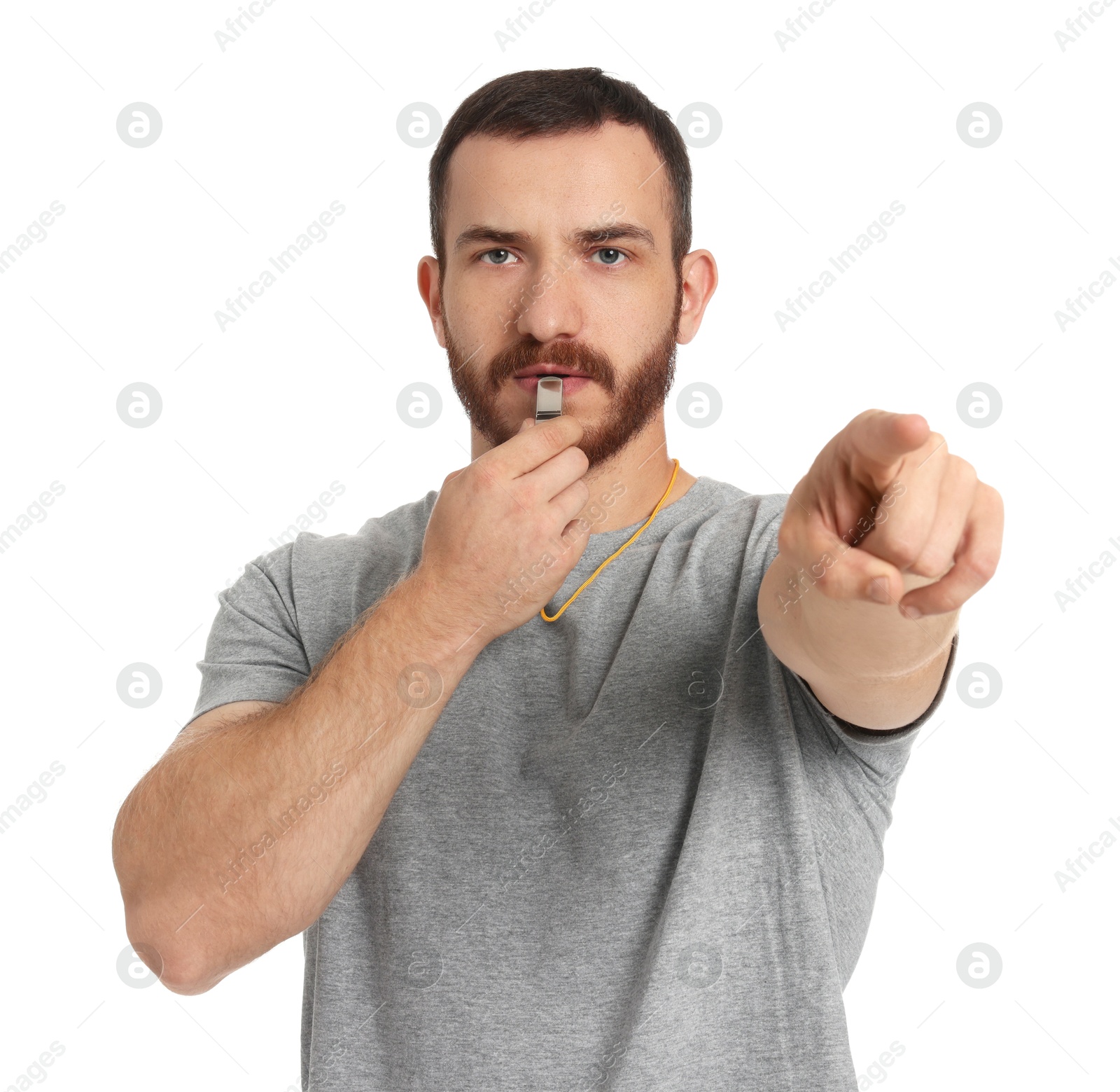 Photo of Young man blowing whistle on white background