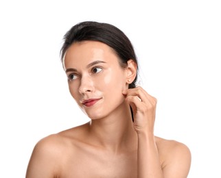 Photo of Beautiful woman peeling off face mask on white background