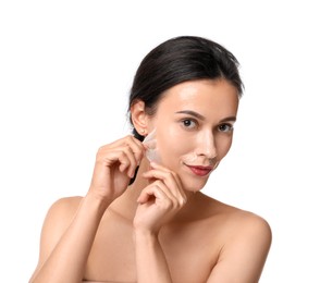 Photo of Beautiful woman peeling off face mask on white background