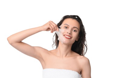 Smiling woman peeling off face mask on white background