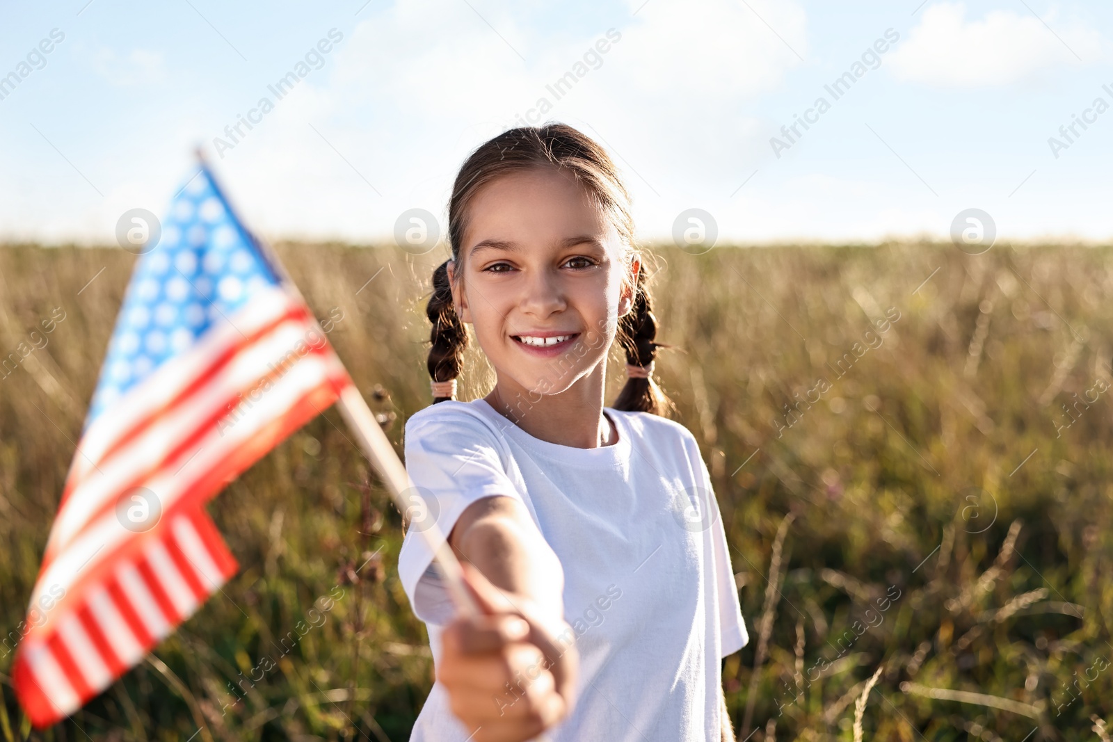 Photo of Happy girl with flag of USA outdoors