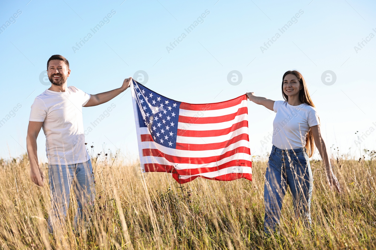 Photo of Happy couple with flag of USA outdoors