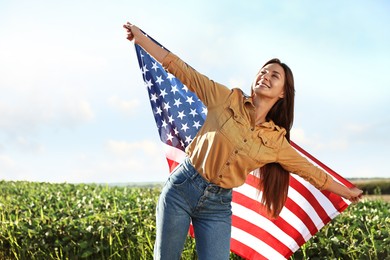 Photo of Happy woman with flag of USA outdoors. Space for text