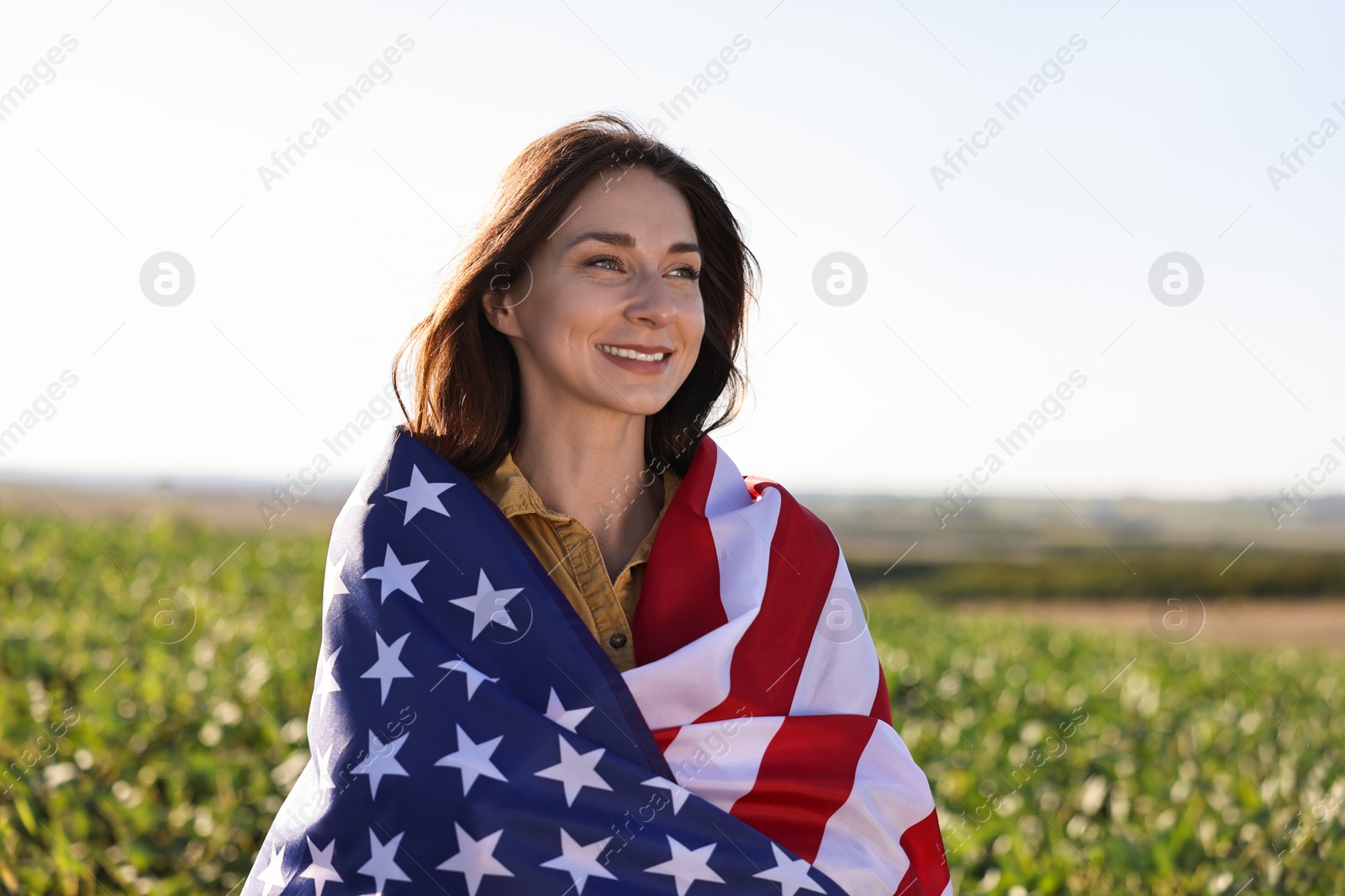 Photo of Happy woman with flag of USA outdoors