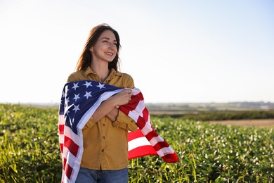 Photo of Happy woman with flag of USA outdoors. Space for text