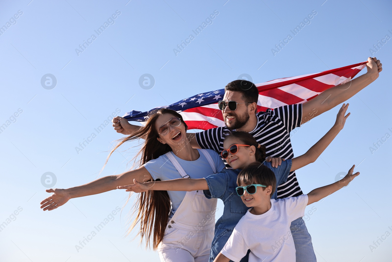 Photo of Happy family with flag of USA outdoors