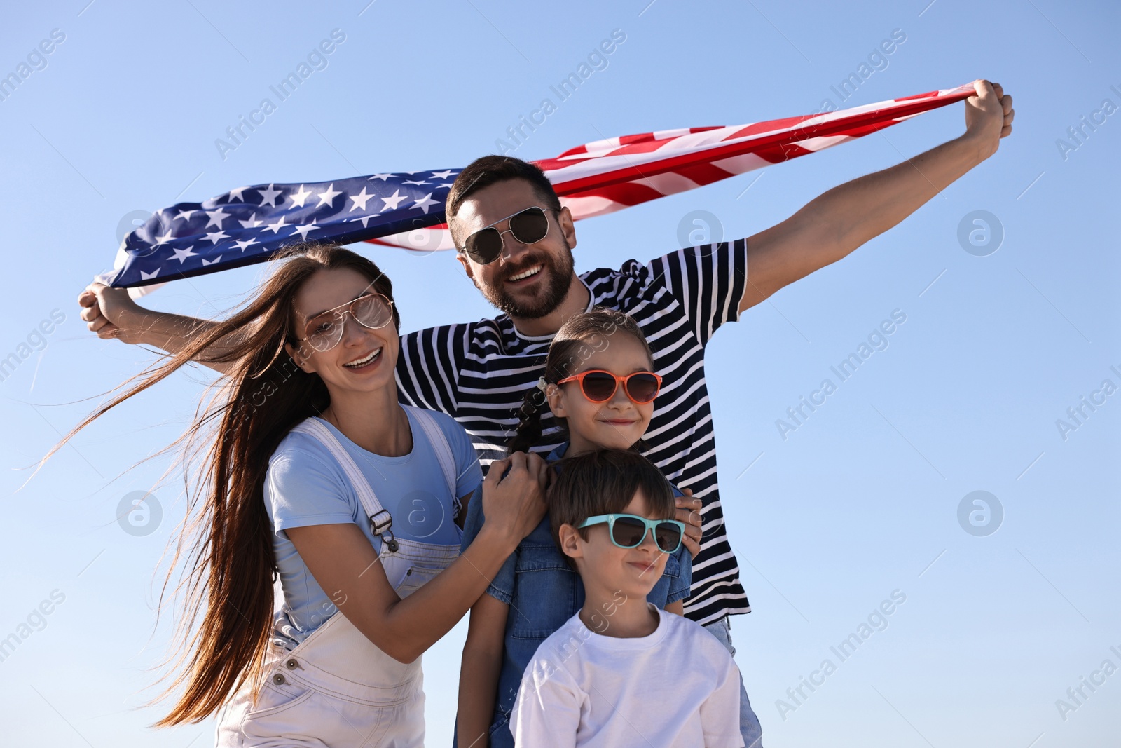 Photo of Happy family with flag of USA outdoors