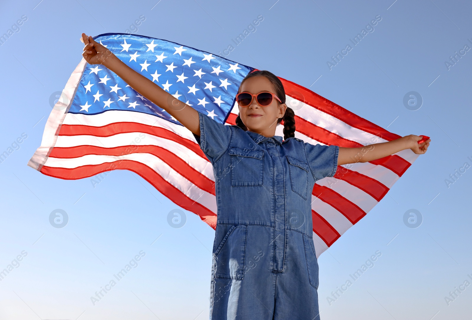 Photo of Little girl with flag of USA outdoors