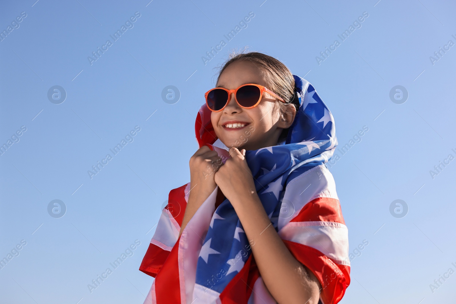 Photo of Happy girl with flag of USA outdoors. Space for text