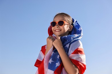 Photo of Happy girl with flag of USA outdoors. Space for text