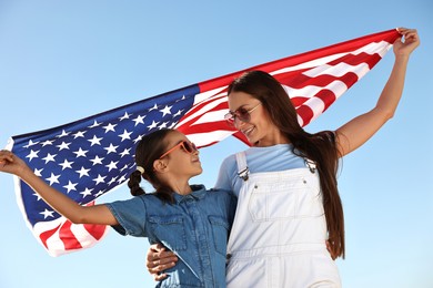 Photo of Happy mother and daughter with flag of USA outdoors